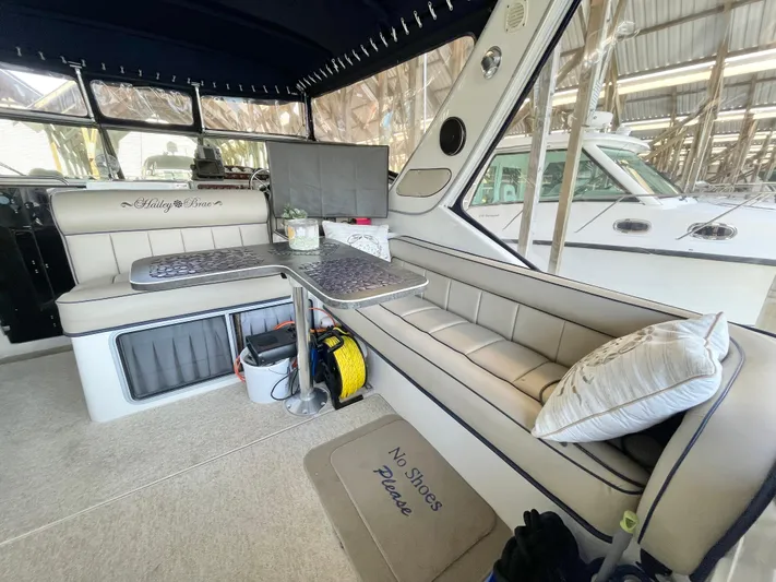 Hailey Brae Yacht Photos Pics Interior of 2021 Custom Express Cruiser with seating, table, and "No Shoes Please" mat.