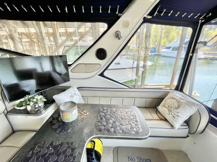 Hailey Brae Yacht Photos Pics Luxurious 2021 Custom Express Cruiser interior with seating, TV, and scenic marina view.