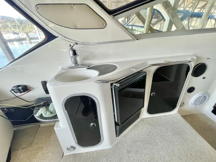 Hailey Brae Yacht Photos Pics 2021 Custom Express Cruiser interior with sink, mini fridge, and storage cabinets.