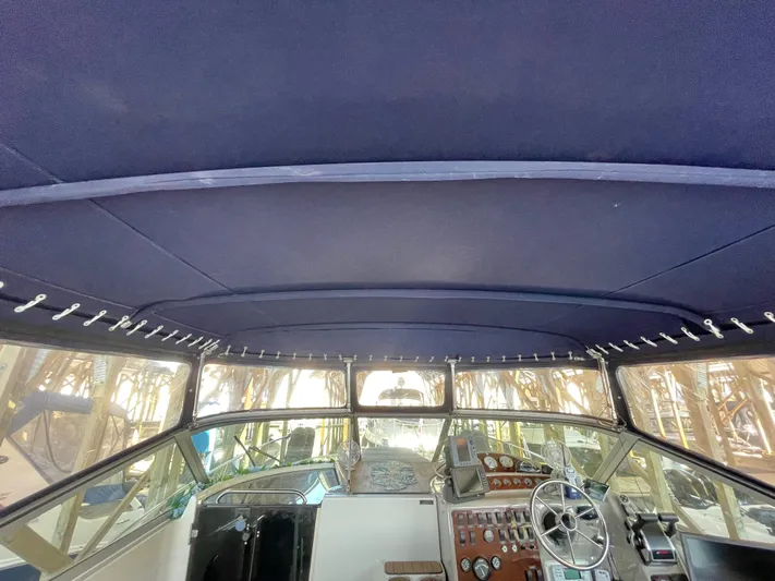 Hailey Brae Yacht Photos Pics Interior view of a 2021 Custom Express Cruiser boat cockpit with steering wheel and dashboard.