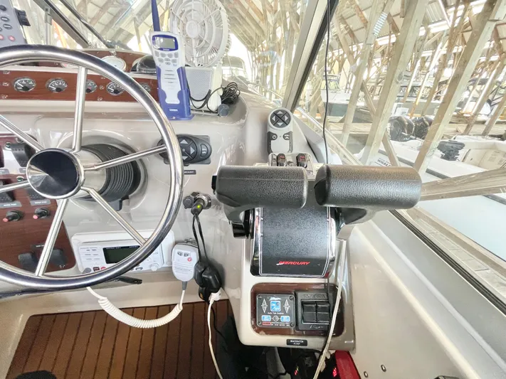 Hailey Brae Yacht Photos Pics Helm of 2021 Custom Express Cruiser with steering wheel and control panel in a marina setting.