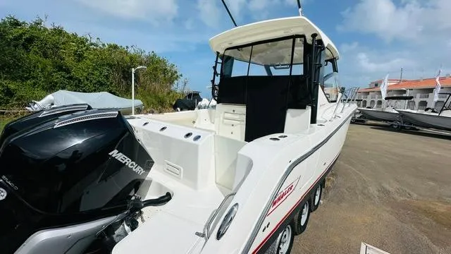  Yacht Photos Pics 2023 Boston Whaler 325 boat with Mercury engine, parked outdoors under a blue sky.