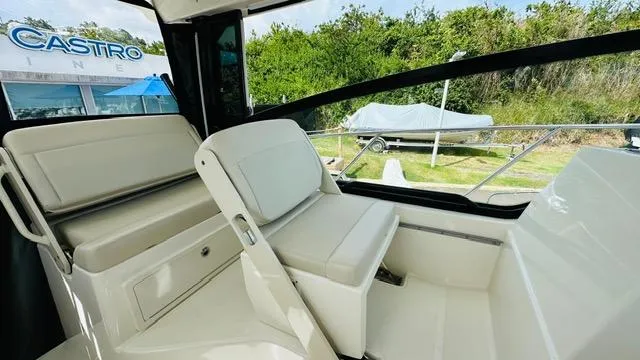  Yacht Photos Pics Interior of 2023 Boston Whaler 325 boat with white seating and outdoor view.