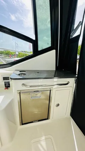  Yacht Photos Pics 2023 Boston Whaler 325 interior with sleek kitchenette and stainless steel accents.