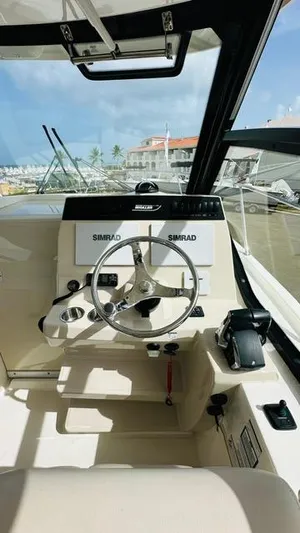  Yacht Photos Pics 2023 Boston Whaler 325 boat cockpit with steering wheel and Simrad navigation system.
