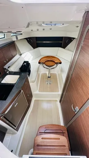  Yacht Photos Pics 2023 Boston Whaler 325 cabin interior with modern amenities and wood accents.