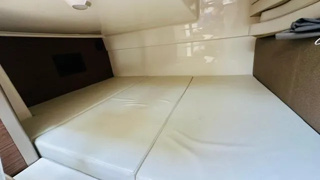  Yacht Photos Pics 2023 Boston Whaler 325 cabin interior with white cushioned seating.