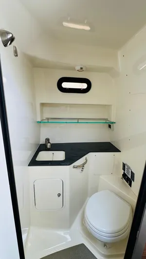  Yacht Photos Pics 2023 Boston Whaler 325 boat interior bathroom with sink, toilet, and shelf.