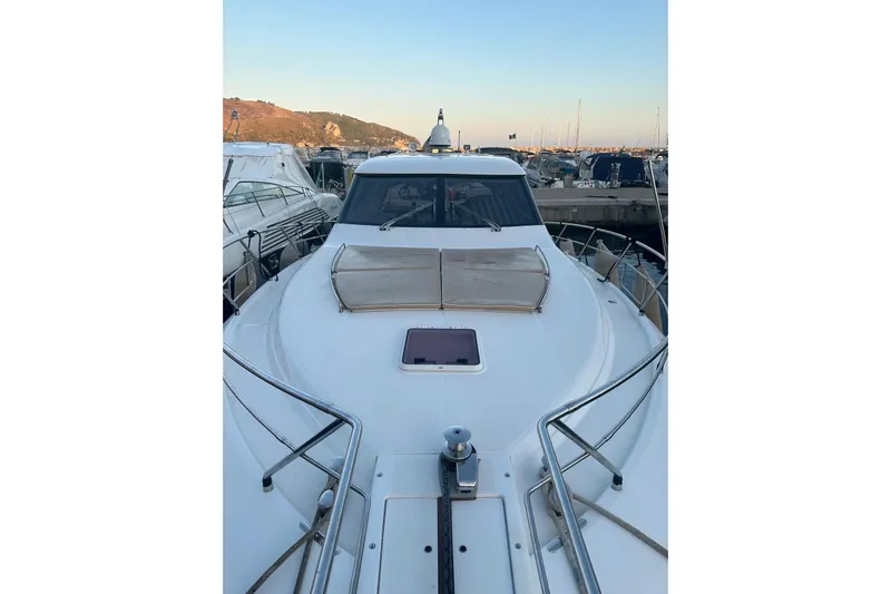  Yacht Photos Pics 2005 Uniesse 48 Open yacht docked at marina, showcasing sleek design and spacious deck.