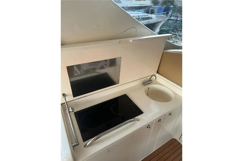  Yacht Photos Pics Compact kitchen area on 2005 Uniesse 48 Open yacht with stove and sink.