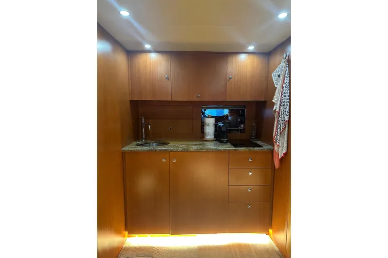  Yacht Photos Pics 2005 Uniesse 48 Open yacht interior kitchen with wooden cabinets and modern lighting.