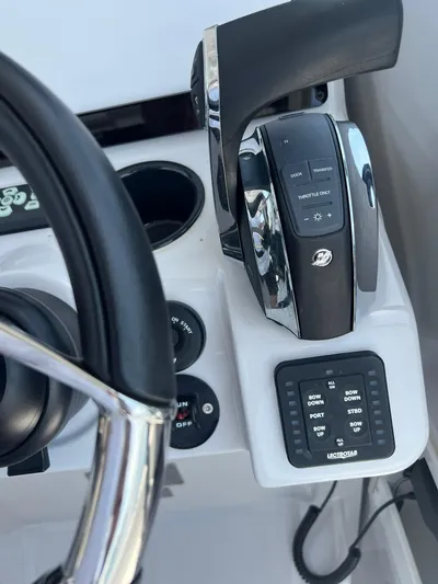  Yacht Photos Pics Control panel of a 2023 RYCK 28 boat with steering wheel and throttle.
