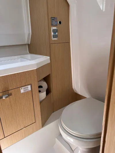  Yacht Photos Pics Modern bathroom interior in 2023 RYCK 28 boat, featuring compact design and wooden cabinetry.