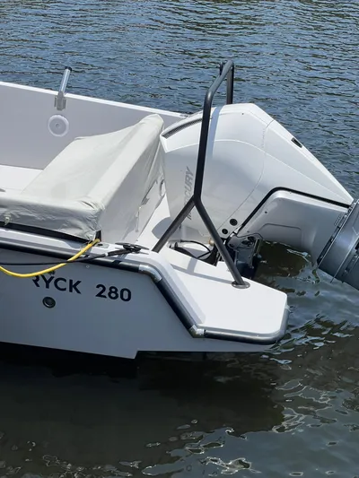 Yacht Photos Pics 2023 RYCK 28 boat with outboard motor on calm water.