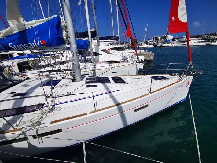 Phat Dolphin Yacht Photos Pics 2019 Jeanneau Sun Odyssey 479 sailboat docked in a marina under clear blue skies.