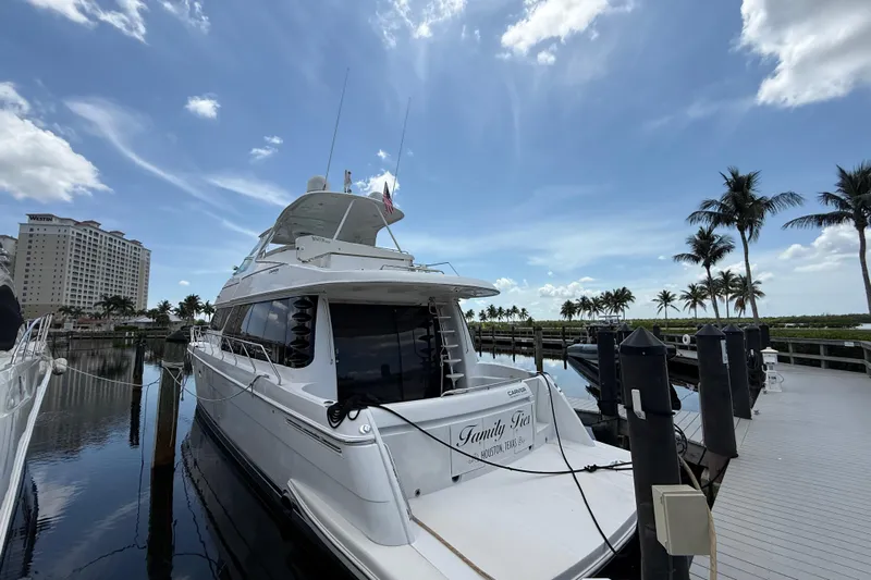  Yacht Photos Pics 2002 Carver 570 Voyager Pilothouse yacht docked at marina with palm trees and blue sky.