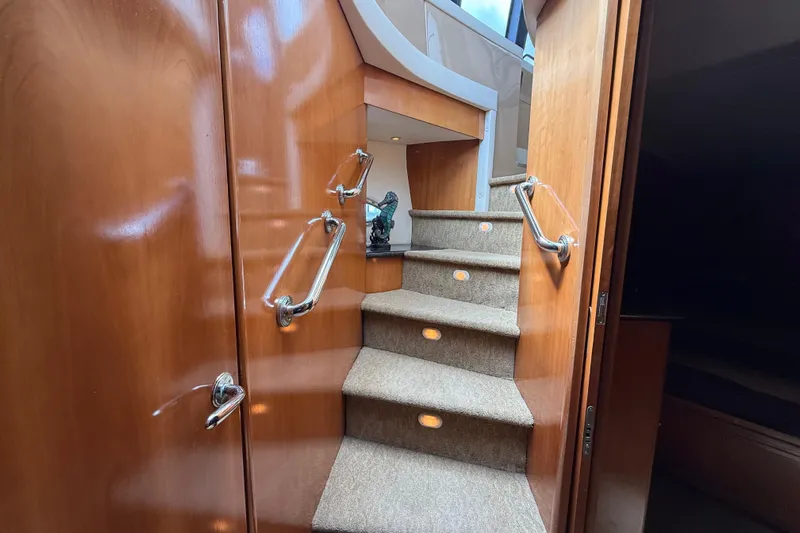  Yacht Photos Pics Interior staircase of 2002 Carver 570 Voyager Pilothouse with wooden finish and carpeted steps.