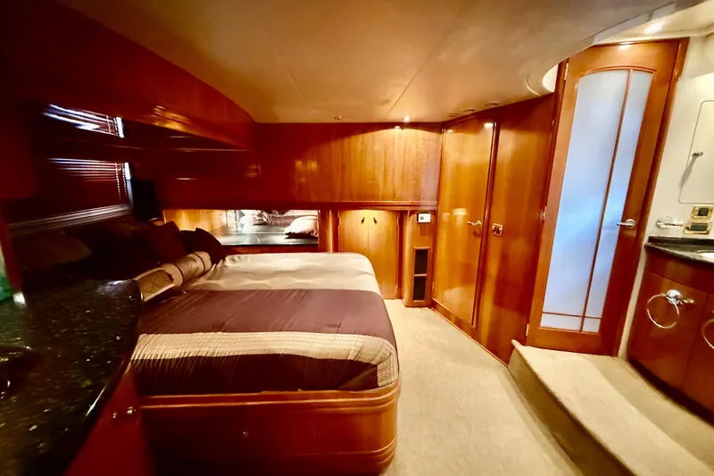  Yacht Photos Pics Luxurious interior of 2002 Carver 570 Voyager Pilothouse with elegant wood finishes and cozy bedding.