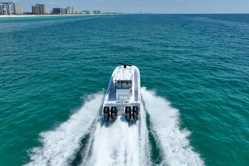  Yacht Photos Pics 2026 Invincible 40 Catamaran cruising on open ocean near city skyline.