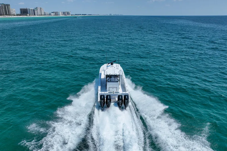  Yacht Photos Pics 2026 Invincible 40 Catamaran cruising on open ocean near city skyline.