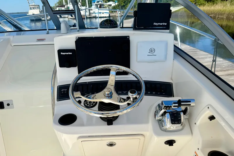  Yacht Photos Pics 2007 Boston Whaler 285 Conquest helm with Raymarine electronics and chrome steering wheel.
