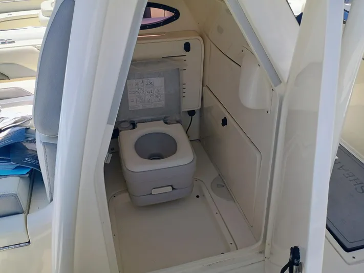 270-912 Yacht Photos Pics 2024 ShearWater 270 Carolina SS Open Bow boat interior with compact marine toilet.