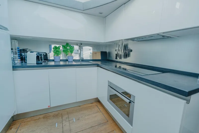 Scuderia Yacht Photos Pics Modern kitchen interior on 2010 Absolute 70 STY yacht, featuring sleek white cabinetry and appliances.