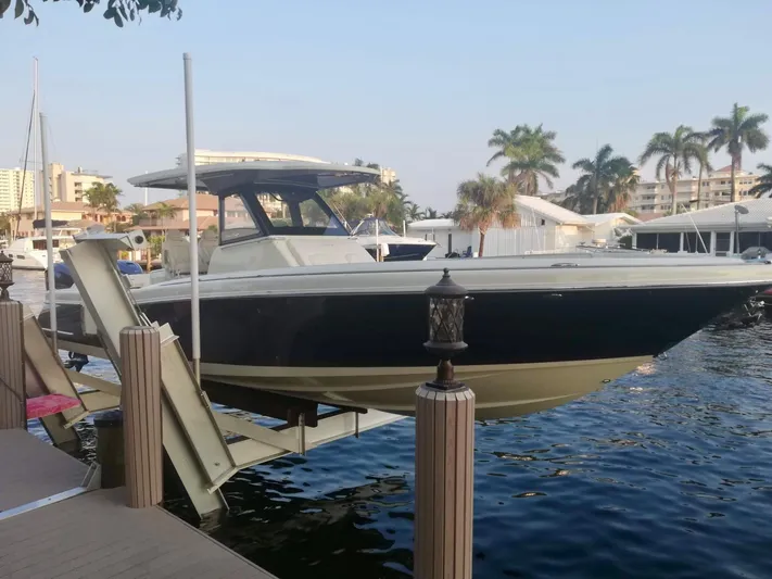  Yacht Photos Pics 2019 Chris-Craft Catalina 34 boat docked, surrounded by palm trees and waterfront buildings.