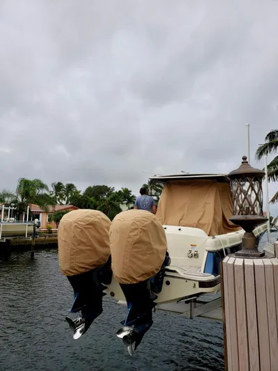 Yacht Photos Pics 2019 Chris-Craft Catalina 34 boat docked, featuring covered outboard motors, under cloudy skies.
