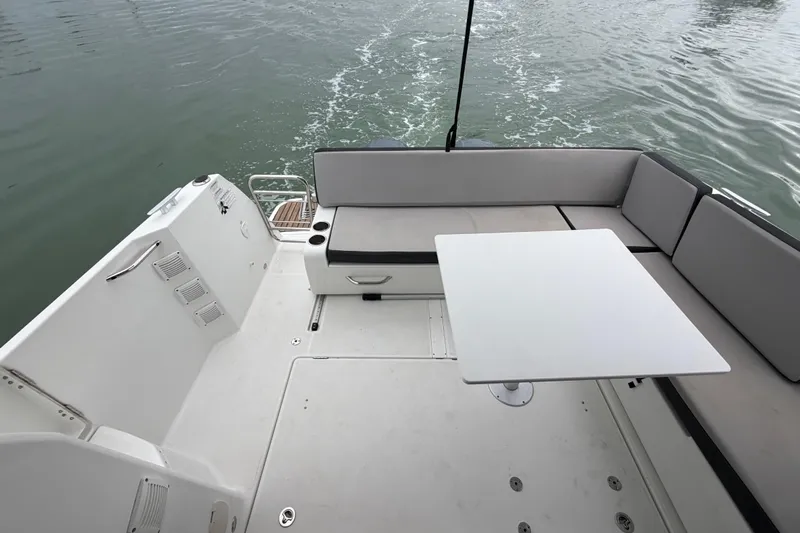  Yacht Photos Pics 2019 Jeanneau NC 895 boat deck with seating and table on calm water.