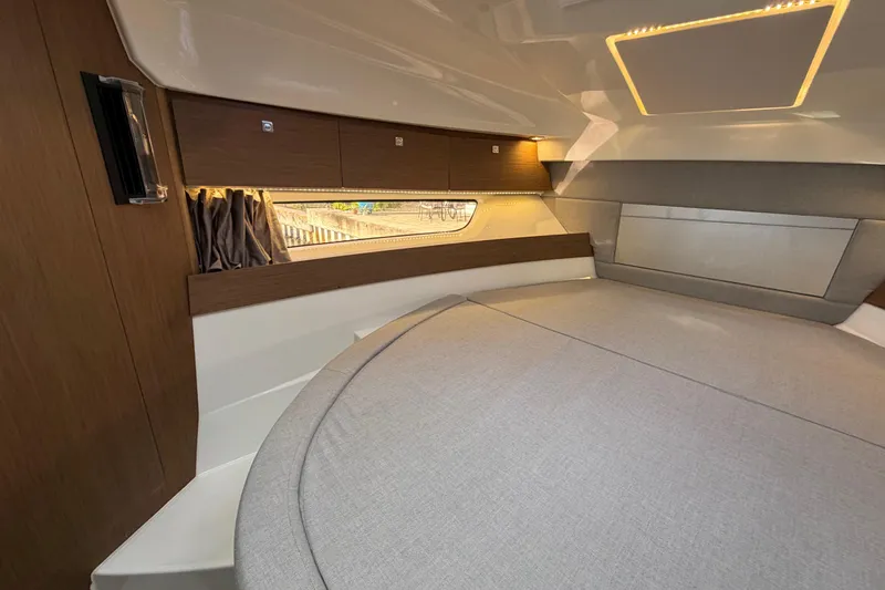  Yacht Photos Pics 2019 Jeanneau NC 895 cabin interior with modern wood finish and cozy bedding.
