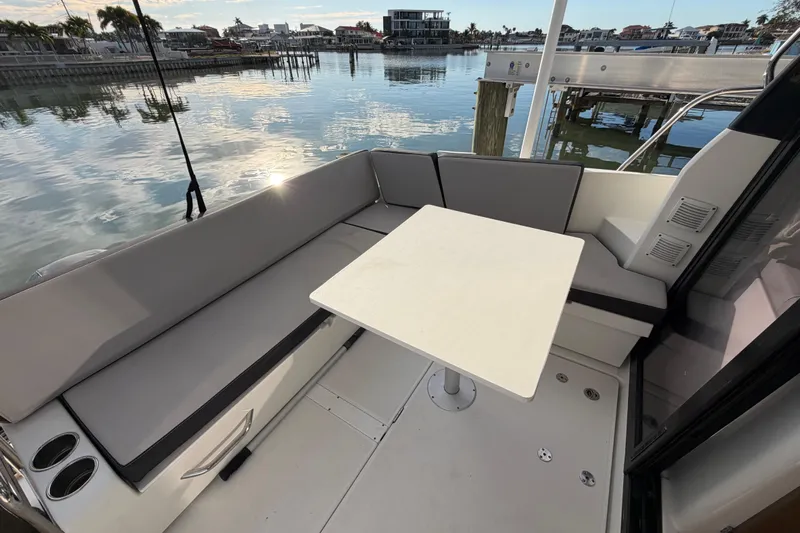  Yacht Photos Pics 2019 Jeanneau NC 895 boat interior with seating and table, docked by calm waters.