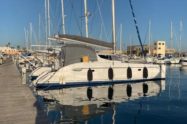  Yacht Photos Pics 2002 Fountaine Pajot LAVEZZI 40 catamaran docked at marina, reflecting on calm water.