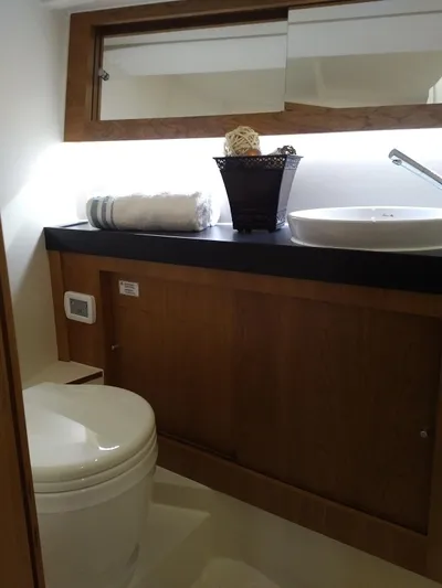  Yacht Photos Pics 2017 Hanse 415 yacht bathroom with modern sink, toilet, and wooden cabinetry.