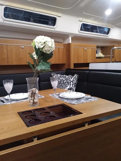  Yacht Photos Pics Elegant interior of 2017 Hanse HANSE 415 yacht with dining setup and floral centerpiece.