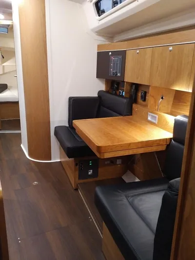  Yacht Photos Pics Interior of 2017 Hanse HANSE 415 yacht with wooden table and black seating.