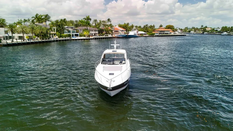 Arbitrage Yacht Photos Pics 2017 Sunseeker Predator 57 yacht cruising in a scenic waterfront area.