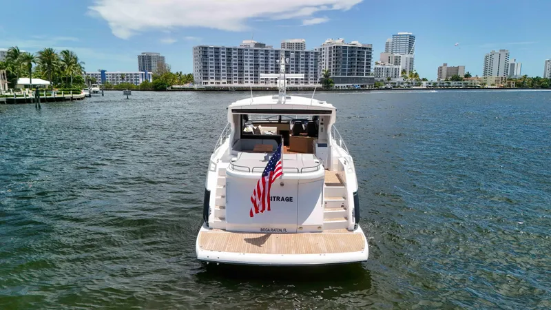 Arbitrage Yacht Photos Pics 2017 Sunseeker Predator 57 yacht on water, city skyline in background.