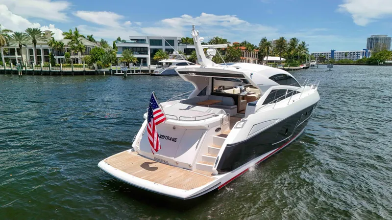 Arbitrage Yacht Photos Pics 2017 Sunseeker Predator 57 yacht cruising on a sunny day, displaying an American flag.