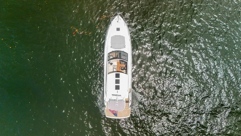 Arbitrage Yacht Photos Pics Aerial view of 2017 Sunseeker Predator 57 yacht on shimmering water.