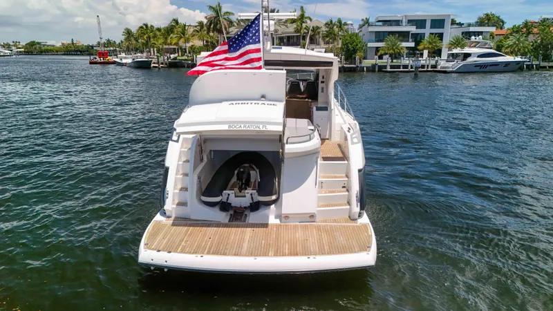 Arbitrage Yacht Photos Pics Sunseeker Predator 57 yacht, 2017 model, docked in Boca Raton, Florida, with American flag.
