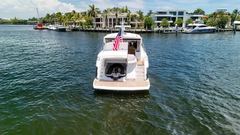 Arbitrage Yacht Photos Pics 2017 Sunseeker Predator 57 yacht on water, rear view, with American flag.