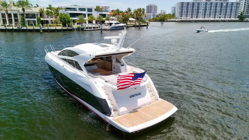 Arbitrage Yacht Photos Pics 2017 Sunseeker Predator 57 yacht cruising in a scenic waterfront area.