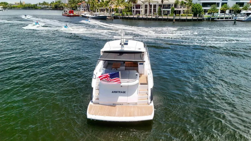 Arbitrage Yacht Photos Pics 2017 Sunseeker Predator 57 yacht cruising on a scenic waterway with American flag.