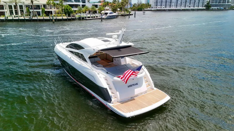 Arbitrage Yacht Photos Pics 2017 Sunseeker Predator 57 yacht cruising on a sunny day, displaying an American flag.