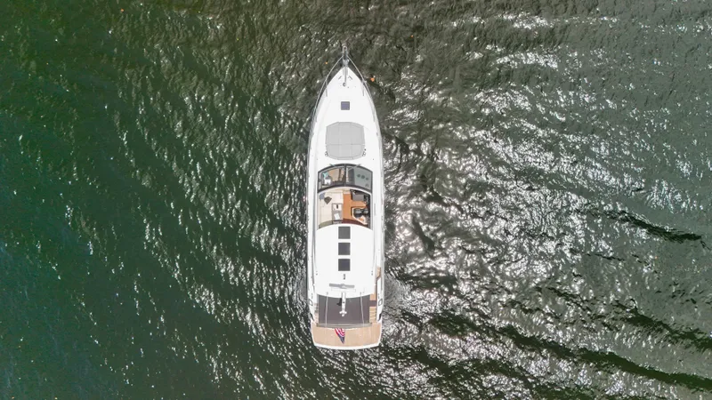 Arbitrage Yacht Photos Pics Aerial view of 2017 Sunseeker Predator 57 yacht on shimmering water.