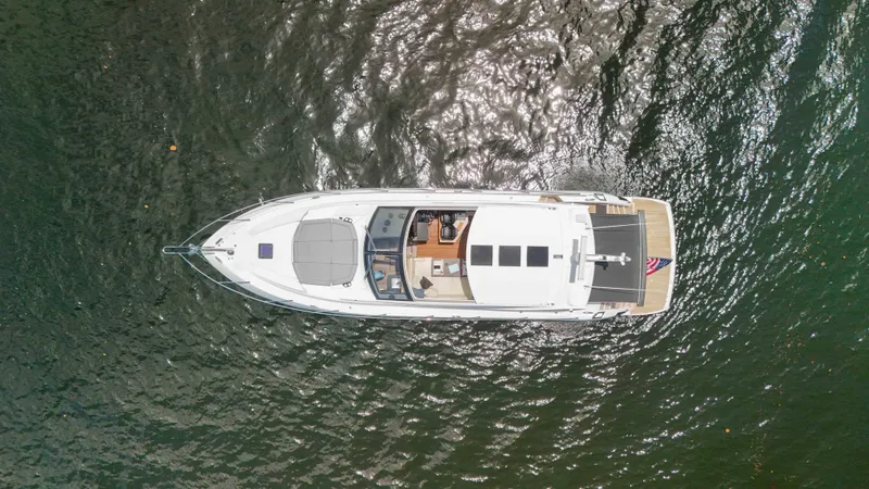 Arbitrage Yacht Photos Pics Aerial view of 2017 Sunseeker Predator 57 yacht on shimmering water.