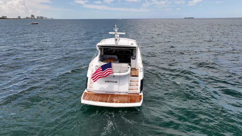 Arbitrage Yacht Photos Pics 2017 Sunseeker Predator 57 yacht on open water, rear view with American flag.