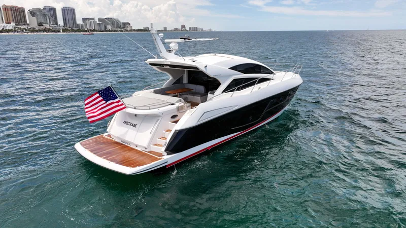 Arbitrage Yacht Photos Pics 2017 Sunseeker Predator 57 yacht cruising on open water with city skyline in background.