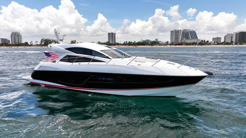 Arbitrage Yacht Photos Pics 2017 Sunseeker Predator 57 yacht cruising near a coastal city skyline.